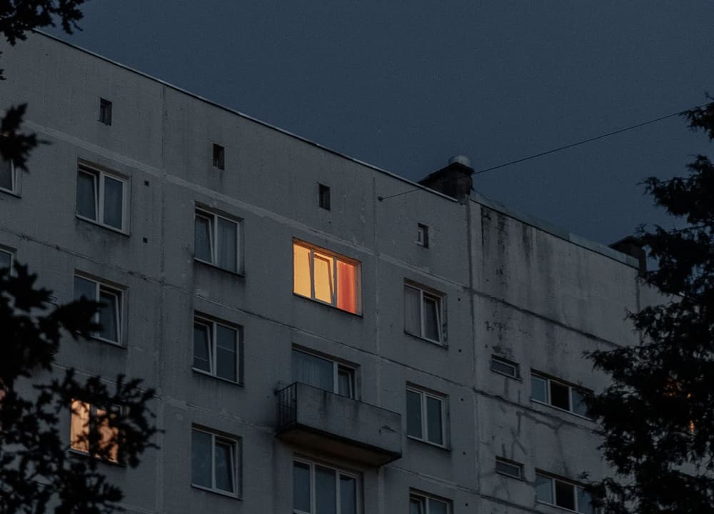 An apartment building with its windows lit at twilight