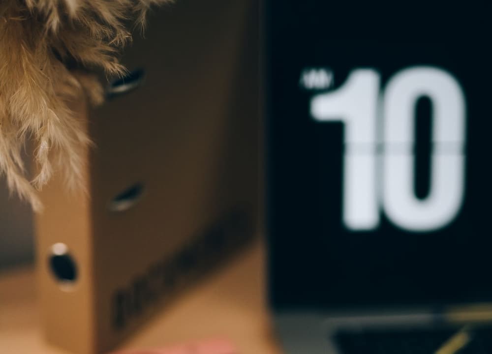An office desk with a laptop and a pair of glasses on it