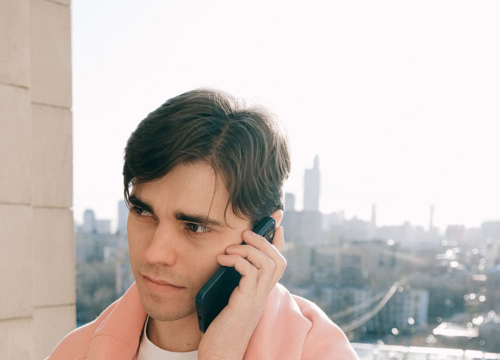 Someone taking a call on a balcony above the city