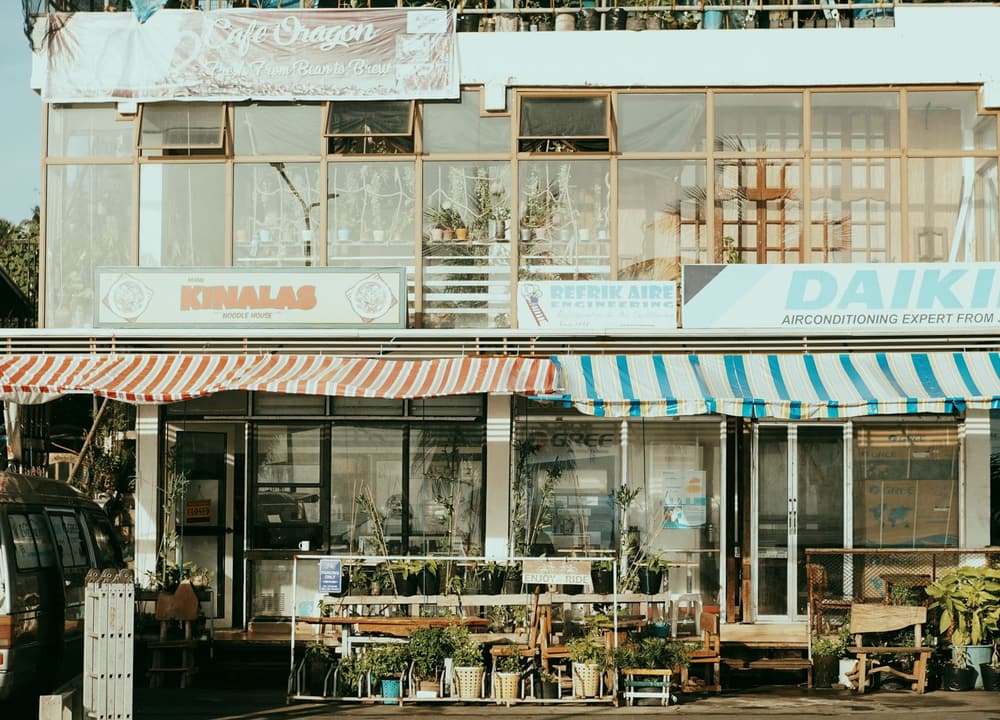 A row of shopfronts under striped awnings on one street
